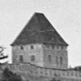Castle sits atop a hill, surrounded by dense forest.