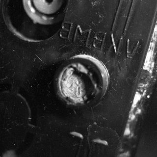 Close-up of corroded metal with visible screws and rust.