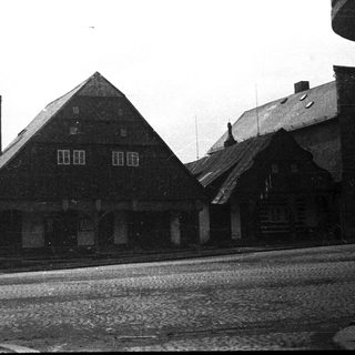Black and white image of buildings with a chimney.