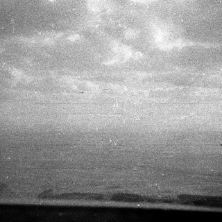 Monochromatic image of a dark horizon and cloudy sky.