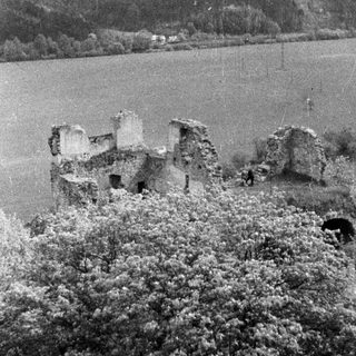 Ruined castle remains overlooking a body of water.