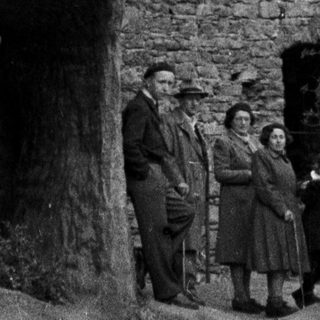 Group poses near ruins of a stone structure.