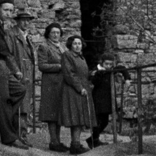 Group poses near ruins of a stone structure.
