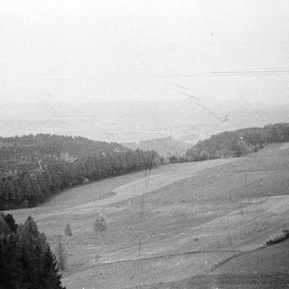 Hilly, forested landscape under a hazy, overcast sky.