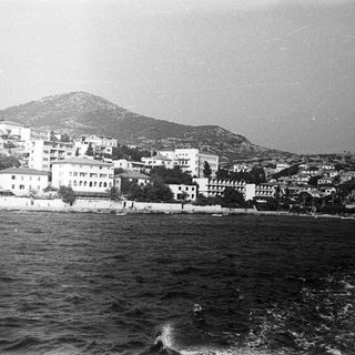 Coastal town nestled at the base of a mountain.