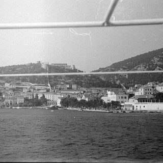 Coastal town with a hillside castle overlooking the water.