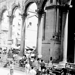 People gather within a historic, columned public space.