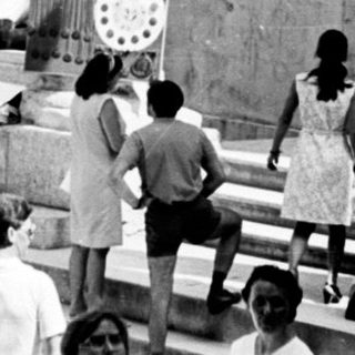 People gather within a historic, columned public space.