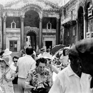 Black and white photo shows tourists in an ancient structure.