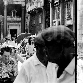 Black and white photo shows tourists in an ancient structure.