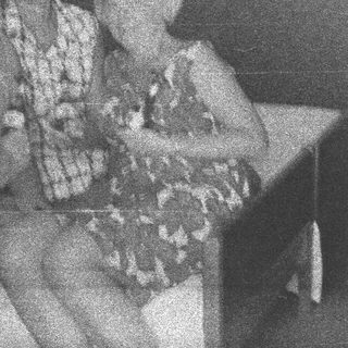 Here's a brief summary of the image: Two people seated on a bench, appearing relaxed.