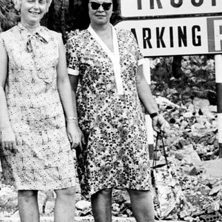 Three women pose near a "Trogir Parking" sign.