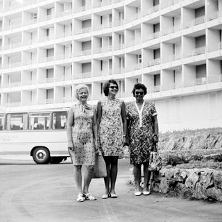 Three women stand in front of a hotel in the 1960s.