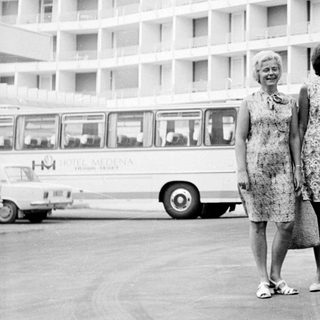Three women stand in front of a hotel in the 1960s.