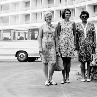 Three women stand in front of a hotel in the 1960s.