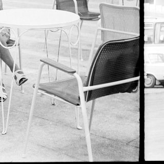 Two women sit at a table in a patio setting.