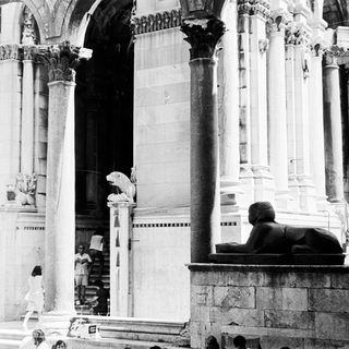 Black and white photo of a grand, columned interior.
