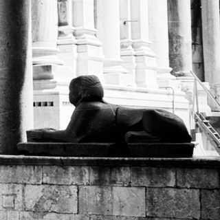 Black and white photo of a grand, columned interior.