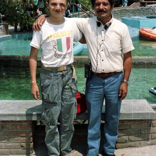 Boy and man posing near a water park.