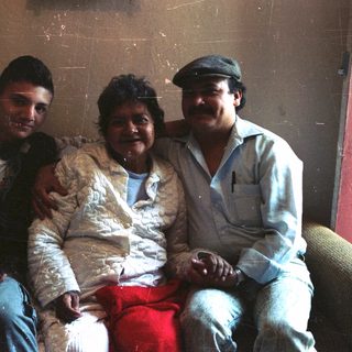 Three people are sitting together on a sofa.