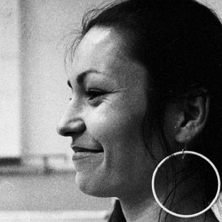 Woman in a tank top, profile view, with long hair.
