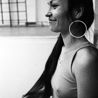 Woman in a tank top, profile view, with long hair.
