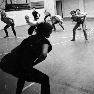 Group of people exercising in a gymnasium setting.