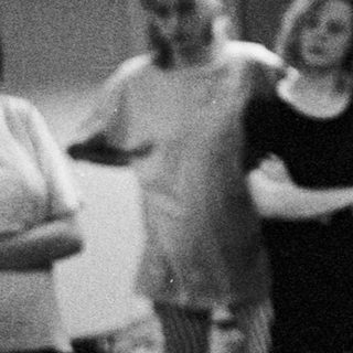 A man speaks to a group of women in a room.