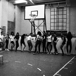 Black and white photo of a dance class in a gym.