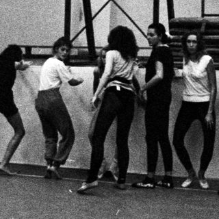 Black and white photo of a dance class in a gym.