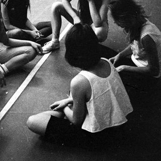 Group of young women sitting and talking on a floor.