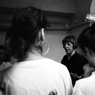 A man speaks to a group of people indoors.