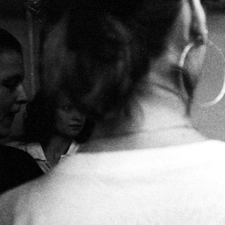 Group of people interact with a woman in a room.