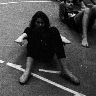 Group of young people relaxing on a basketball court.
