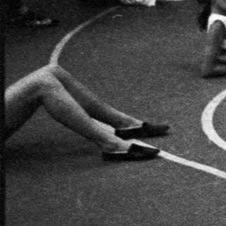 Black and white photo of people stretching on a basketball court.
