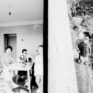 Here's a brief summary of the image: People seated at a table, and a person walking a path.