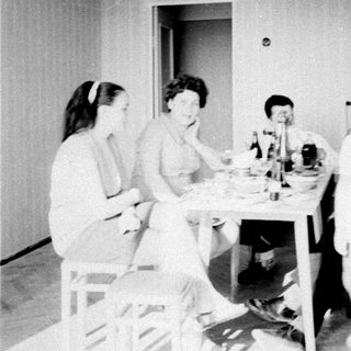 Here's a brief summary of the image: People seated at a table, and a person walking a path.