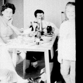 Here's a brief summary of the image: People seated at a table, and a person walking a path.