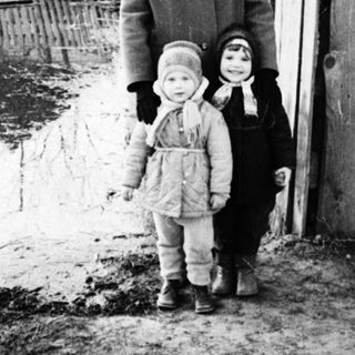 Flooded area with a woman and two children standing nearby.