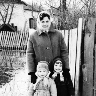 Flooded area with a woman and two children standing nearby.