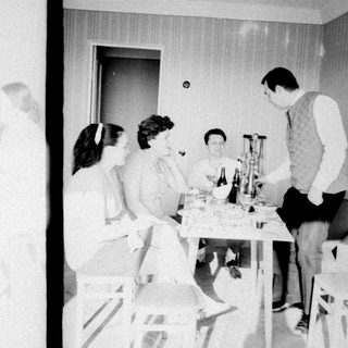 Group gathered around a table, appearing to celebrate or converse.