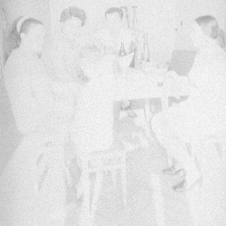 Group gathered around a table, appearing to celebrate or converse.