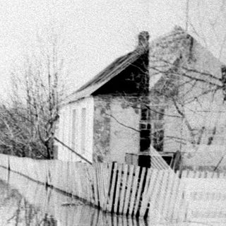 Flooded street with people and a building visible.