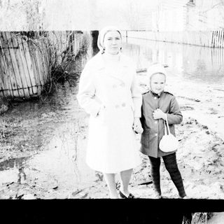 Woman and child standing near a body of water.