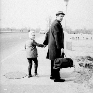 Man and child standing together in a winter landscape.