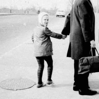 Man and child standing together in a winter landscape.