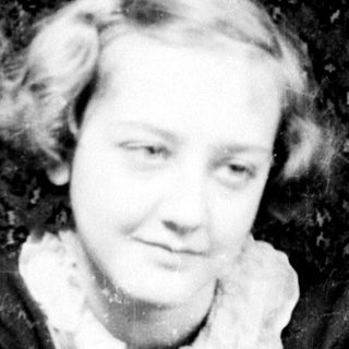 Two women pose for a vintage portrait, smiling.