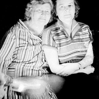 Two women are seated, posed for a black and white portrait.