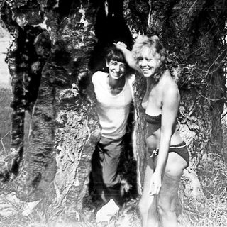 Black and white image of a man and woman near a tree.