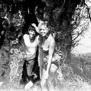 Black and white image of a man and woman near a tree.